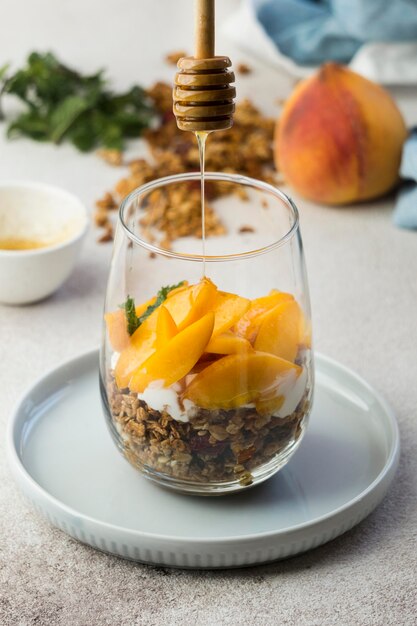 Close-up view of muesli with peaches in glass