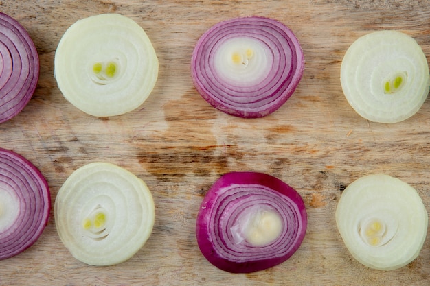 Close-up view of pattern of sliced onions on wooden background