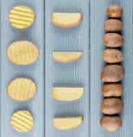 Free photo close up view of pattern of sliced and whole potatoes on wooden background