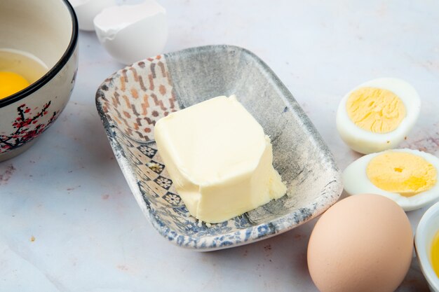 Close-up view of plate of butter with eggs on white background