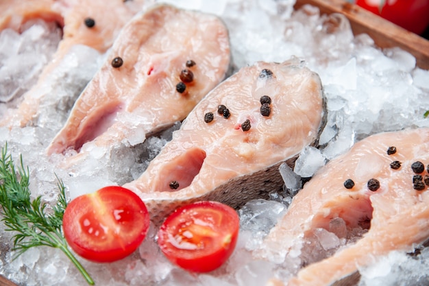 Close-up view raw fish slices with ice tomato slices