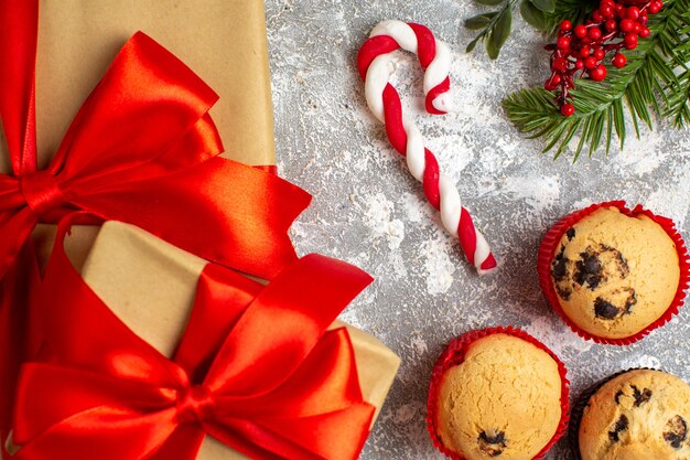 Close up view of small cupcakes Christmas gifts with red ribbon on ice surface