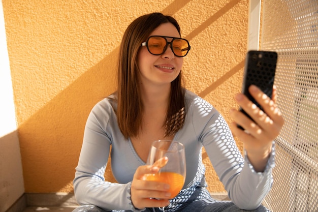 Free photo close up view of smiling woman talk at phone in yellow sunglasses