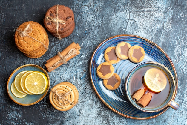 Close up view of tea time with various cookies and hand holding a cup of black tea