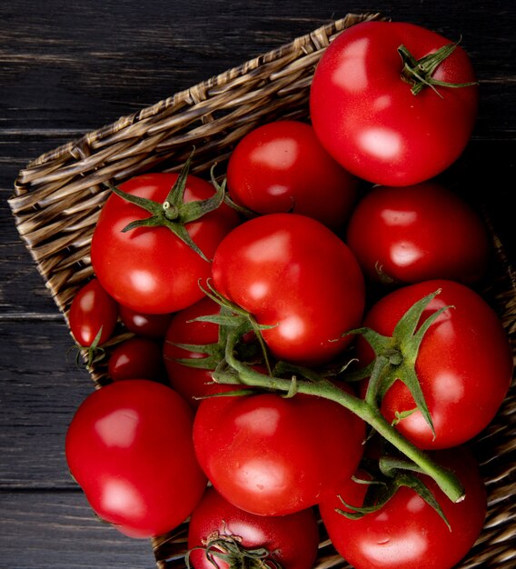 Close-up view of tomatoes in basket plate on wooden table