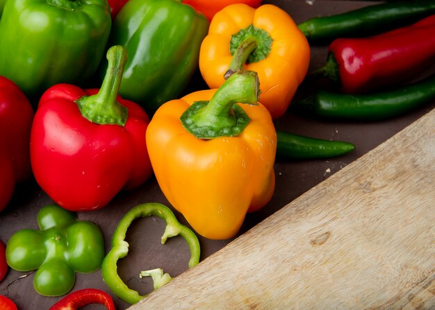 Close-up view of whole and sliced peppers with cutting board