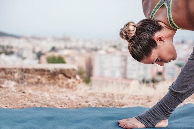 Close up view of woman doing exercise in front of city