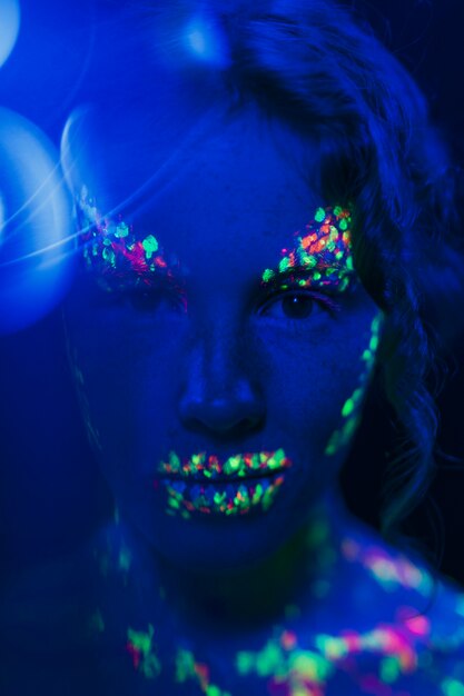 Close-up view of woman with colorful fluorescent make-up