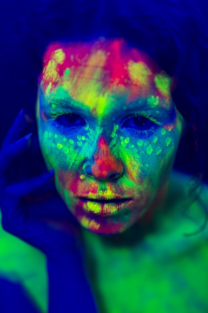 Close-up view of woman with colorful fluorescent make-up