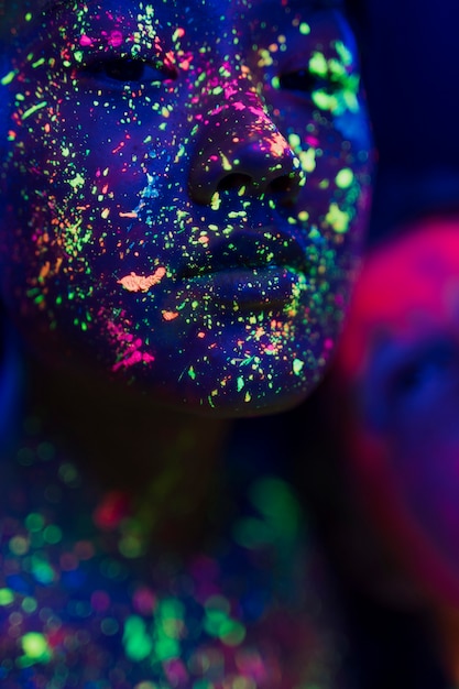 Close-up view of woman with fluorescent make-up