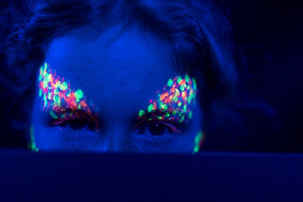 Close-up view of woman with fluorescent make-up