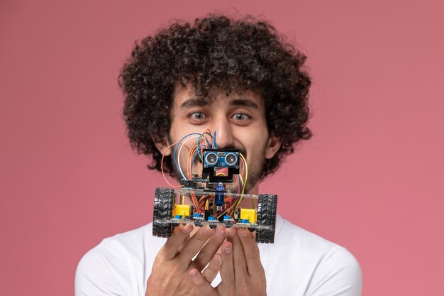 Close up view young man smiling and staring at electronic innovation