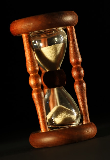 Free photo close-up vintage hourglass with black background