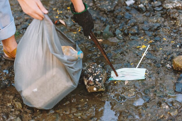 Close up volunteer environment conservation help to keep and clean up plastic and foam garbage on beach and park areaVolunteering world environment day