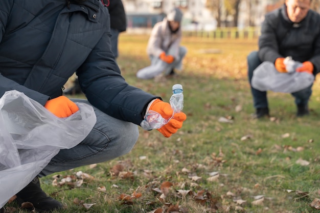 Close up volunteers collecting garbage