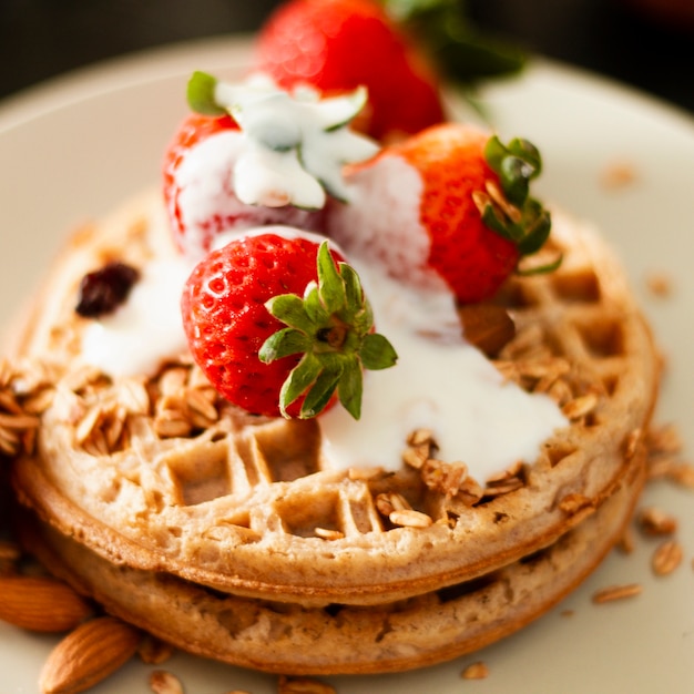 Free Photo close up waffles with strawberries and yogurt