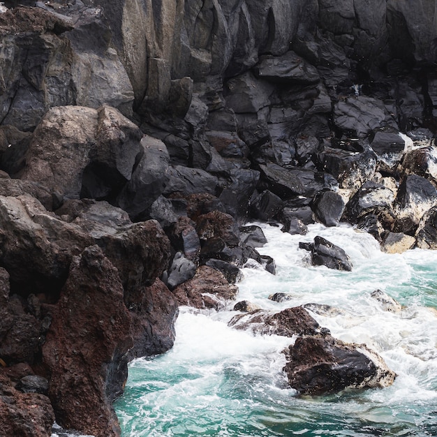 Free Photo close-up wavy water at rocky shore