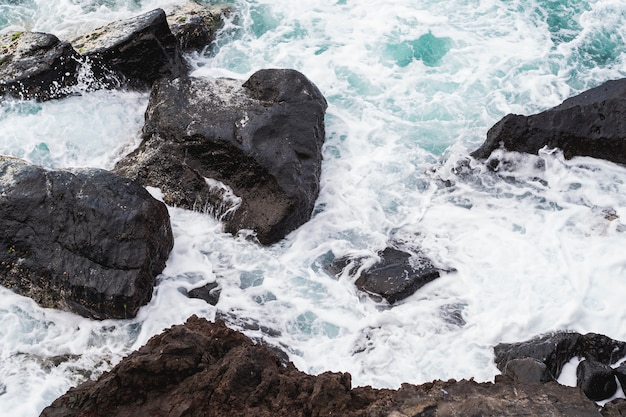 Free Photo close-up wavy water at rocky shore