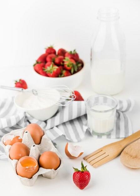 Close-up whisk with strawberries and eggs