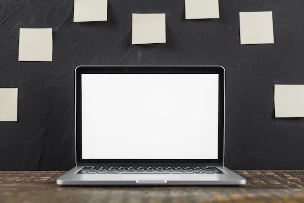 Close-up of a white blank screen laptop on wooden table