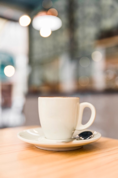 Close-up of white coffee cup on wooden table