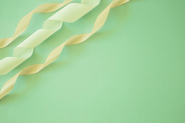 Free photo close-up of white and peach stain ribbon on green backdrop