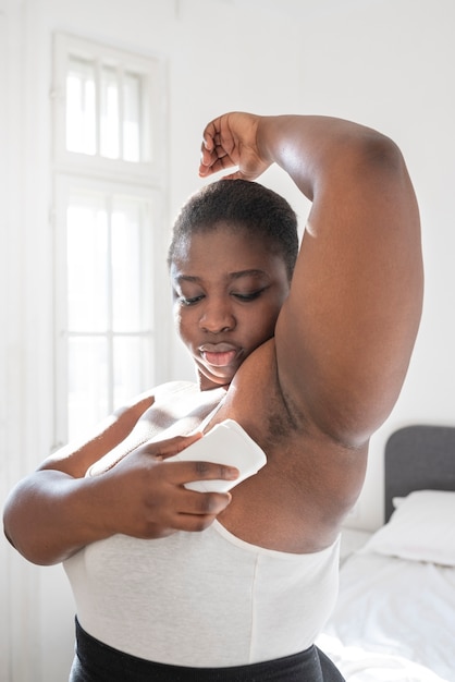 Close up on woman applying deodorant