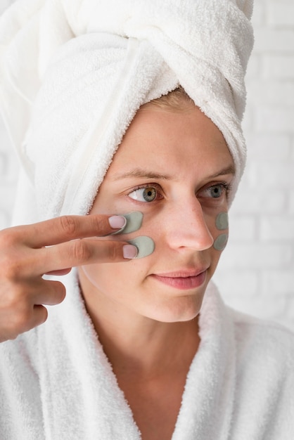 Close-up woman applying face remedy