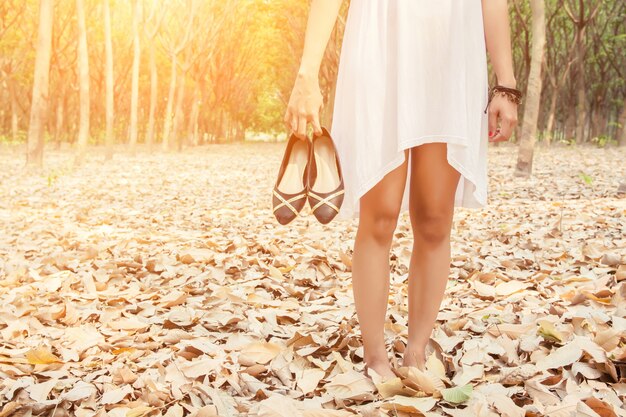 Close-up of woman carrying her shoes in hand