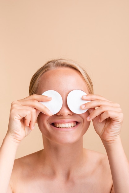 Free Photo close-up woman covering her eyes with cotton pads