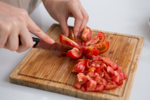 Close-up of woman cutting tomatoes with knife