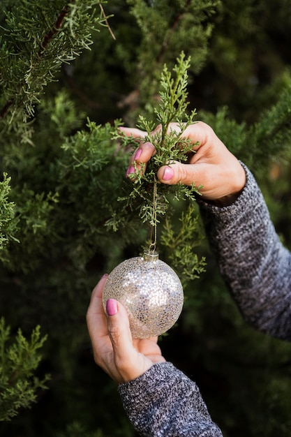 Close-up woman decorating the christmas tree