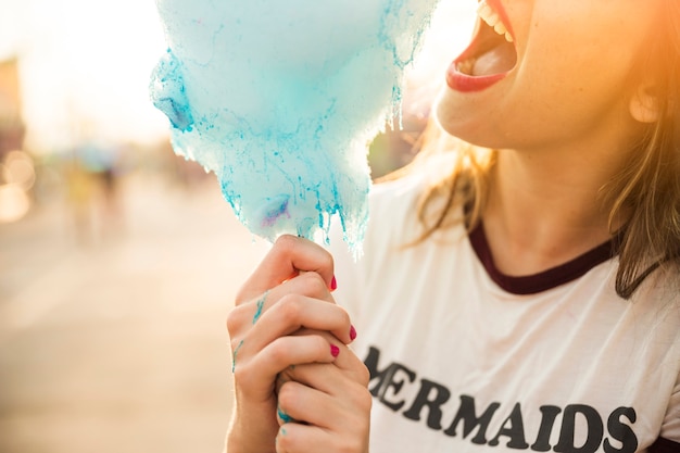 Free photo close-up of a woman eating blue candy floss