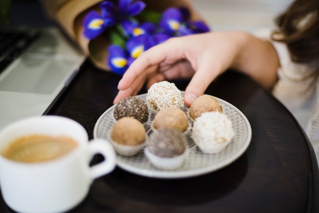 Free Photo close-up of a woman eating different type of truffles on plate