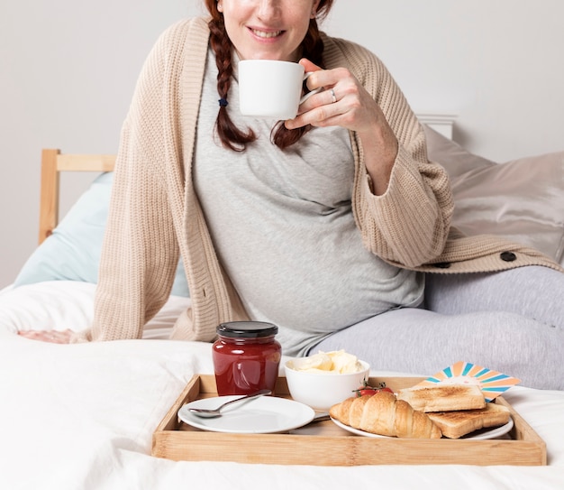 Close-up woman enjoying brunch in bed