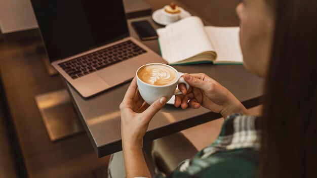 Close up of a woman enjoying a coffee cup