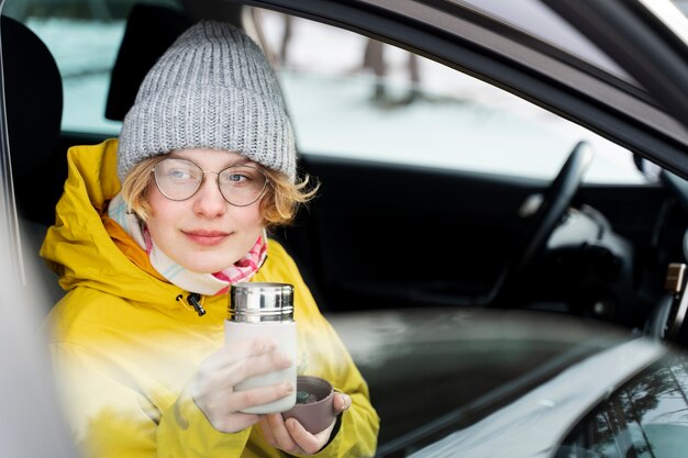 Close up on woman enjoying hot drink while on winter trip