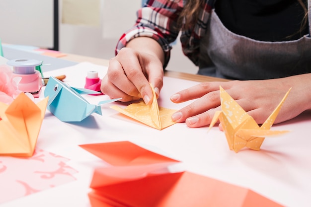 Free Photo close-up of woman hand making creative art craft using origami paper