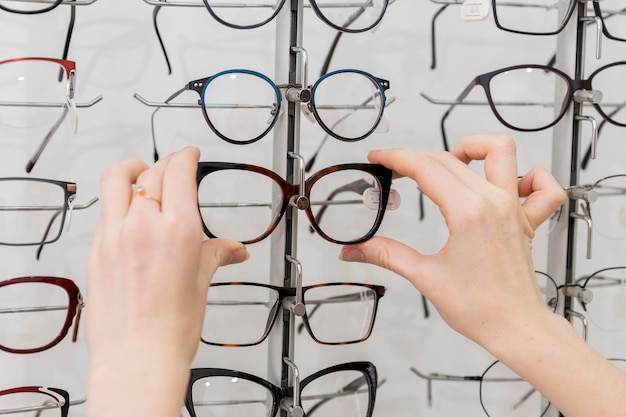 Close-up of woman hand removing eyeglasses from display