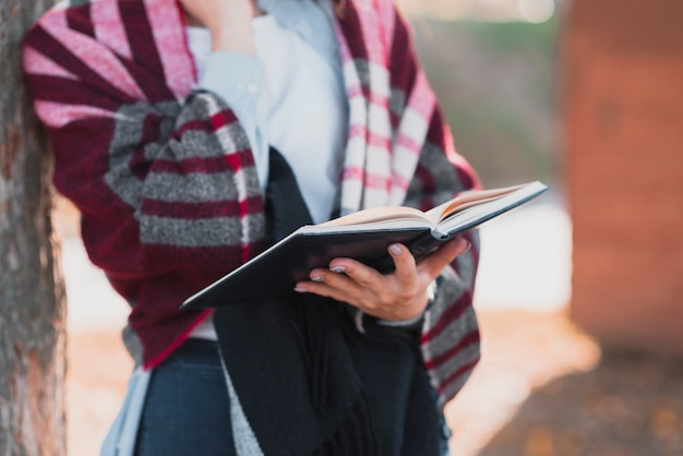 Close-up woman hands holding a notebook