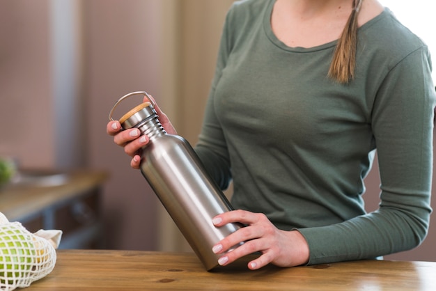 Free Photo close-up woman holding coffee thermos