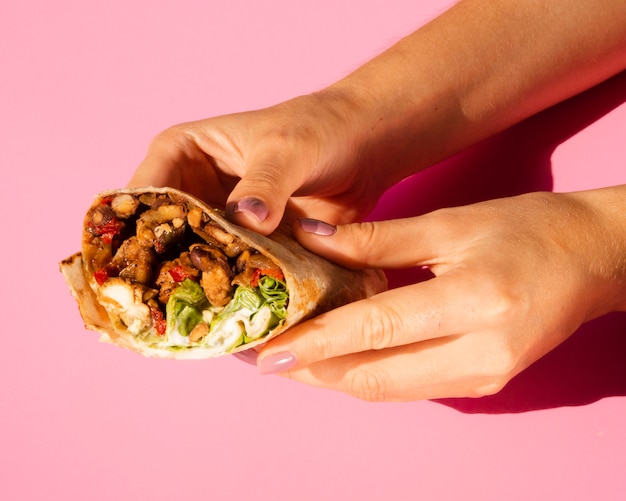 Close-up woman holding delicious burrito