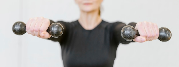 Free Photo close-up woman holding dumbbells