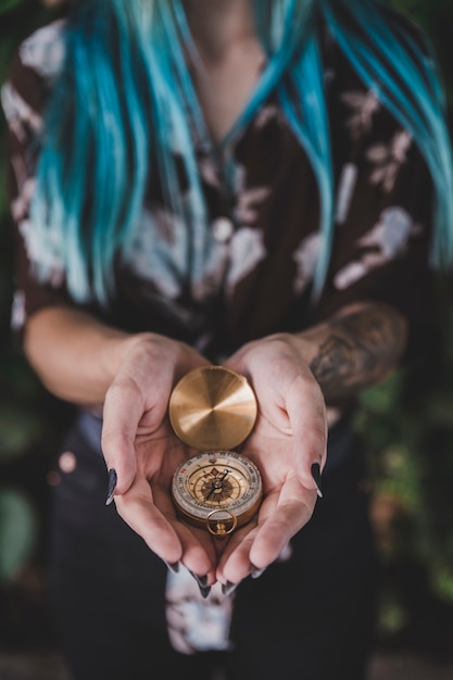 Free photo close-up of woman holding golden vintage compass in hand