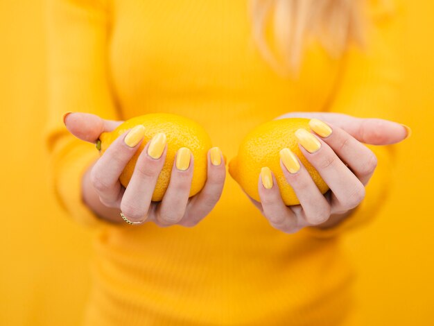 Close-up woman holding lemons