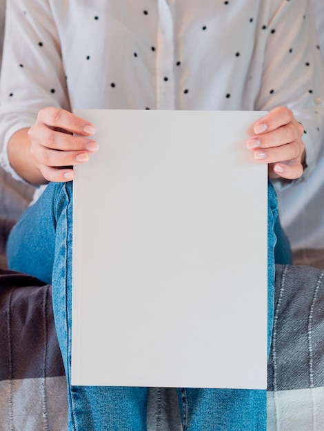 Close-up woman holding a mock-up magazine