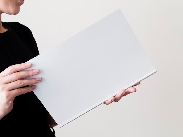 Free photo close-up woman holding a mock-up magazine