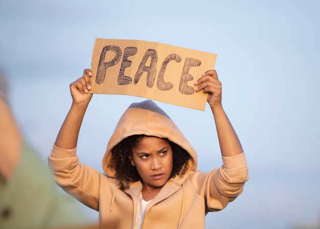 Free photo close up woman holding peace placard