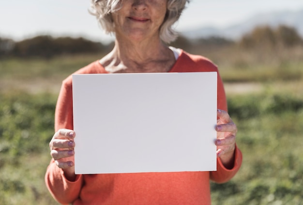 Close-up woman holding a piece of paper