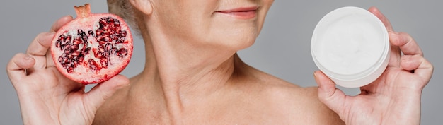 Free photo close-up woman holding pomegranate and cream